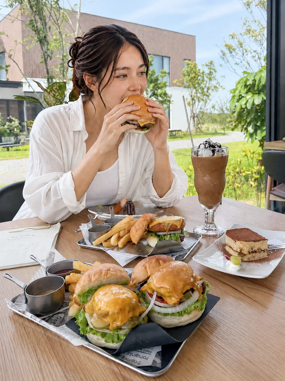 Guests enjoying burgers, fries and drinks by the window at LOHERB