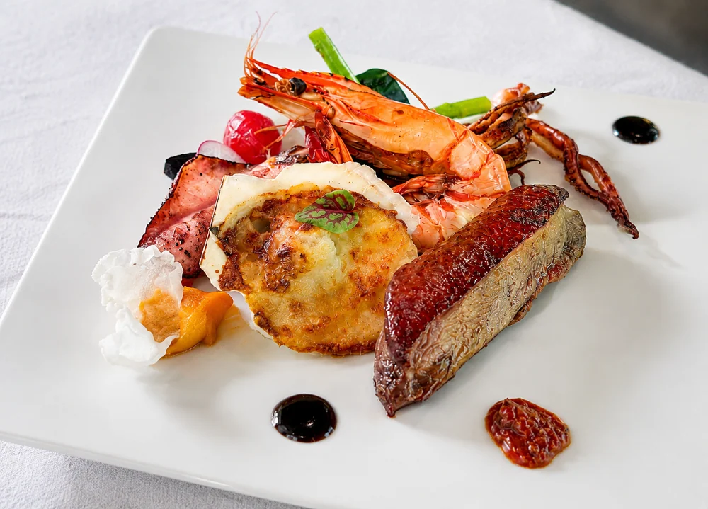 Plated prawns, meat and sauce for a surf-and-turf main at Loherb Cuisine