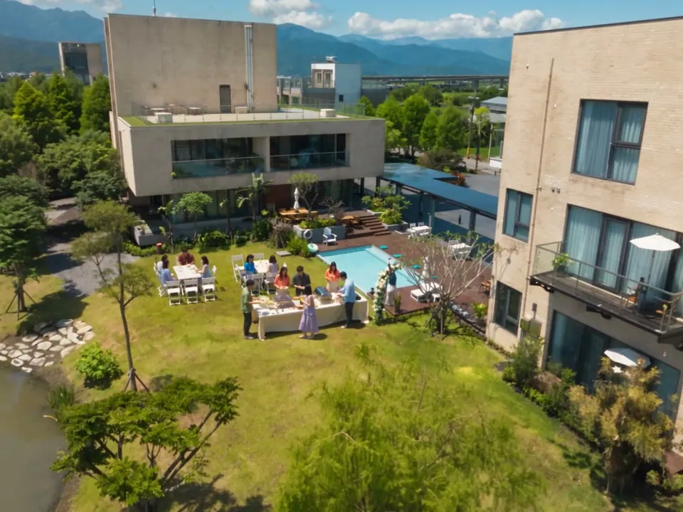 A buffet gathering on the lawn beside the pool at LOHERB T+H