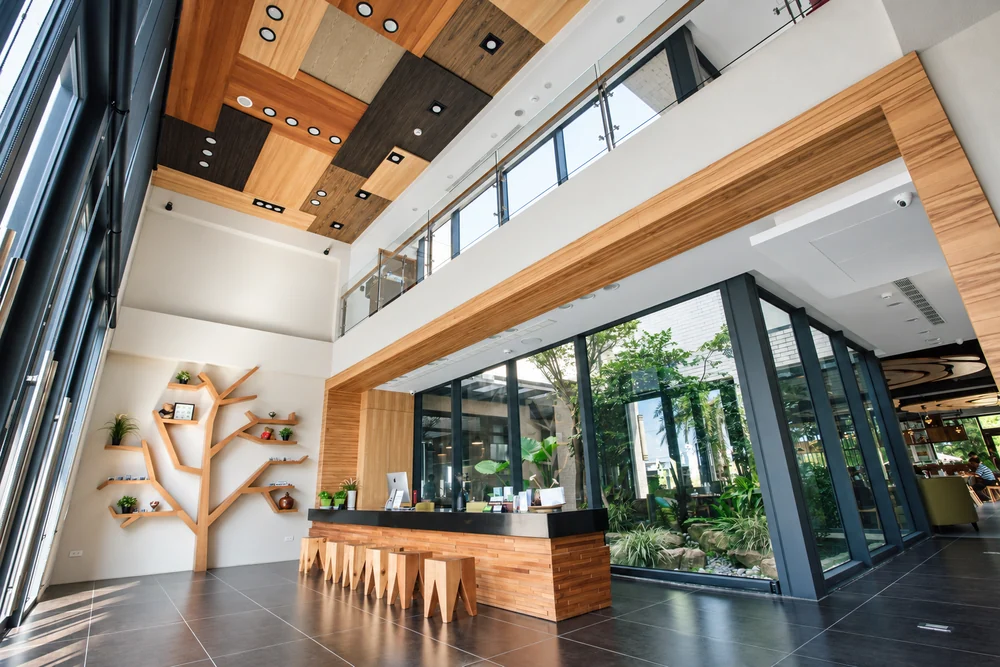 Wooden bar, staircase and tall windows in Flower Villa's double-height reception