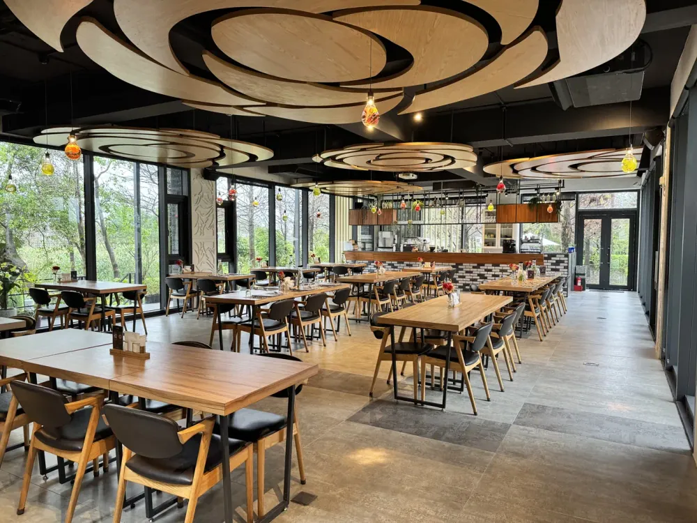Wooden tables, floor-to-ceiling windows and a flower-shaped ceiling at Flower Villa Restaurant